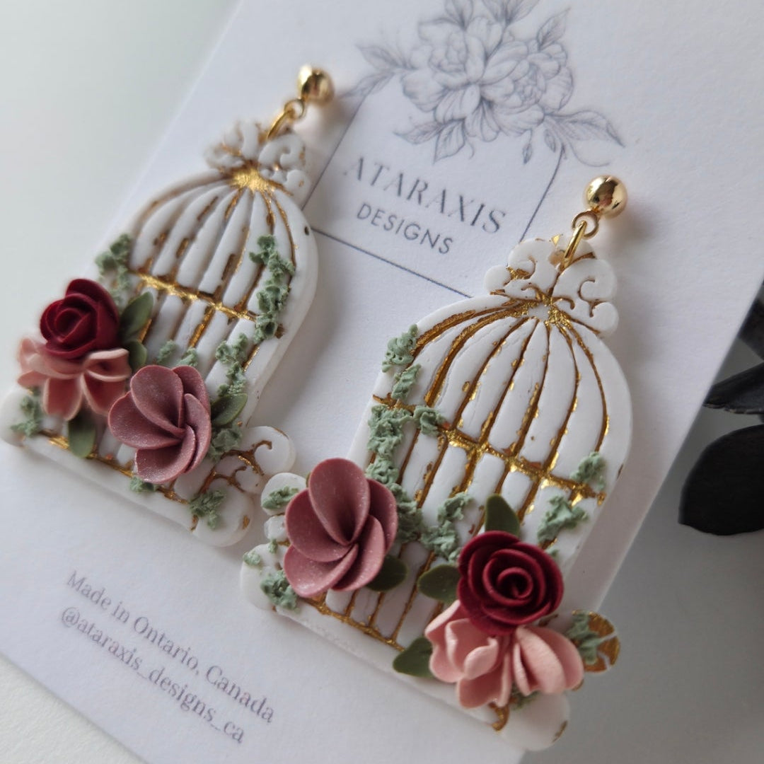 Floral earrings on a branded card with a white background