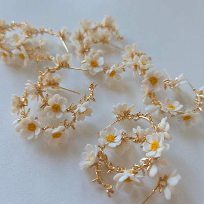 Floral hair accessories with white flowers and gold leaves on a light background