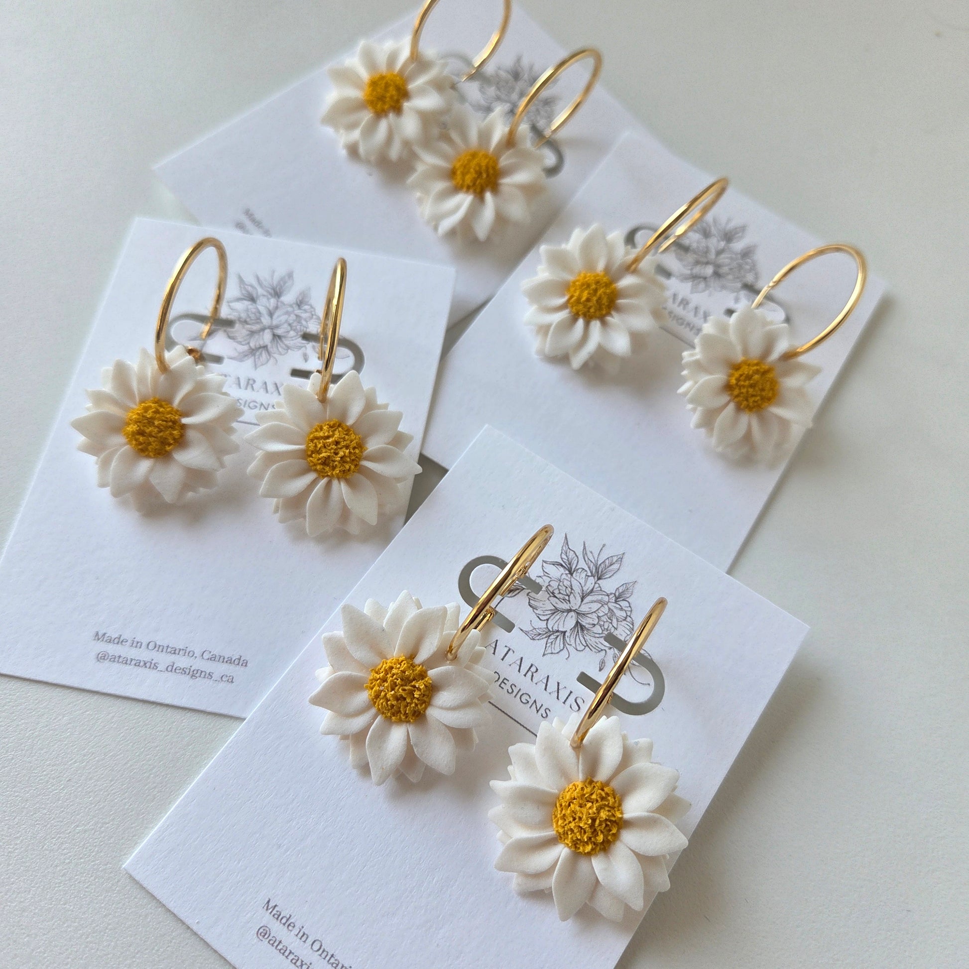 Floral earrings on branded card with white background
