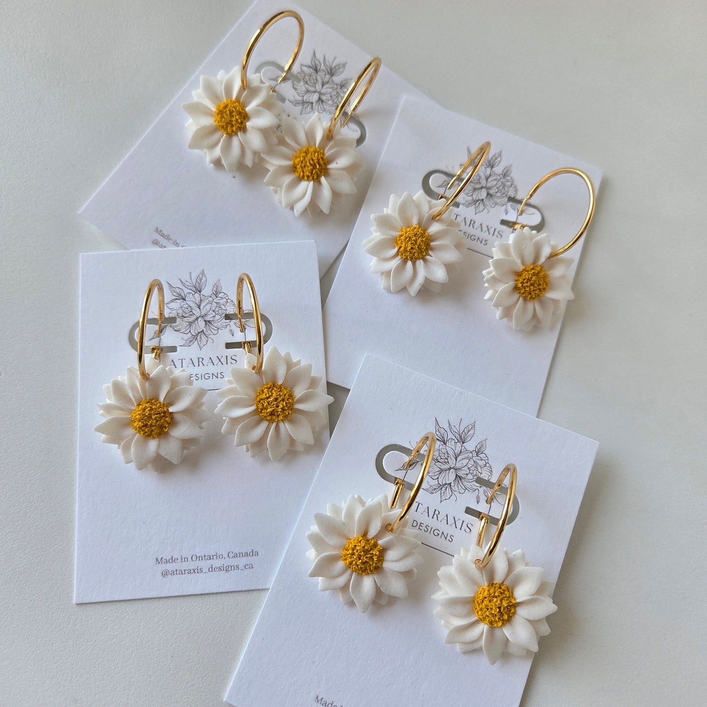 Gold bangles with white flower designs on a white background