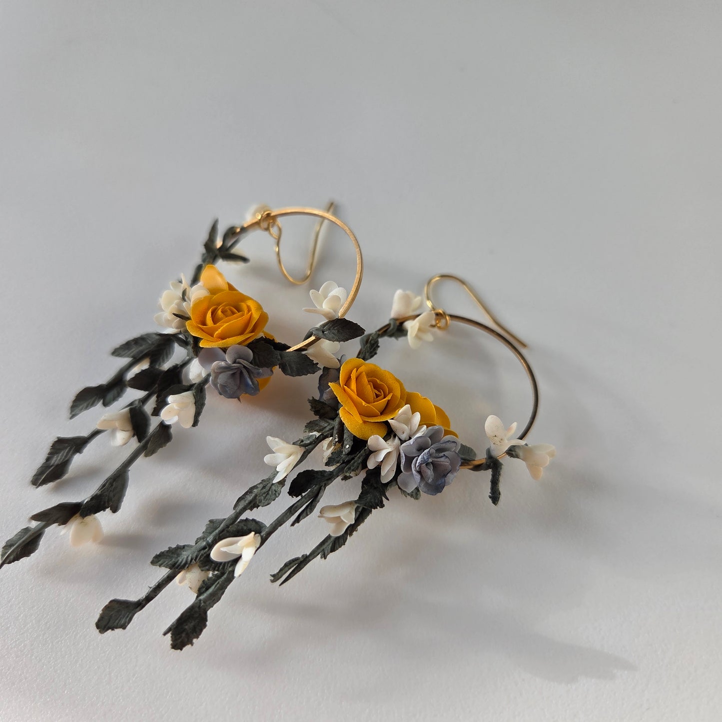 Floral earrings with yellow and gray flowers on a light gray background