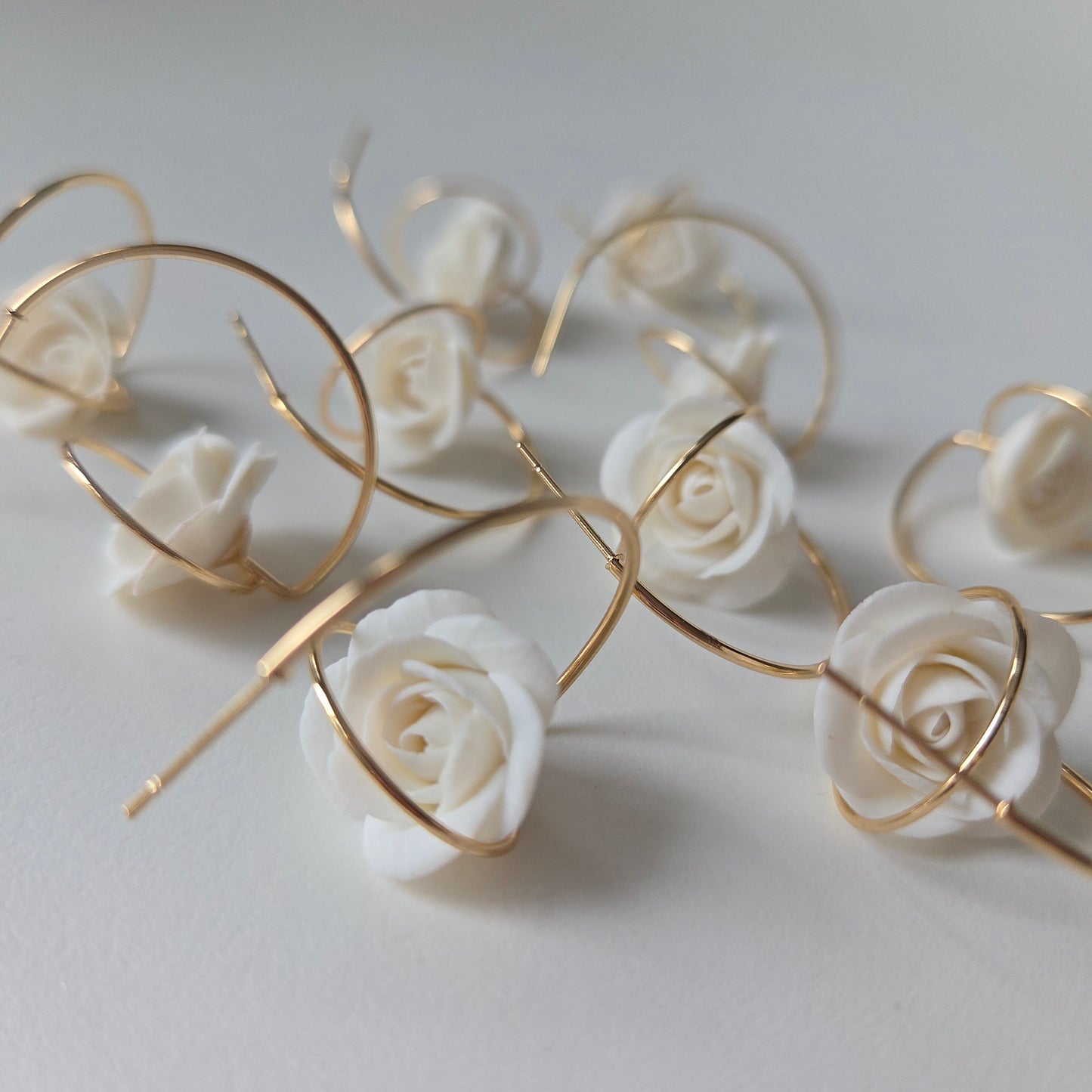 Gold floral earrings with white roses on a 14K gold hoop earring
